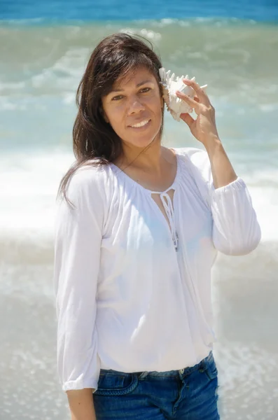 Vacker kvinna med seashell på stranden — Stockfoto