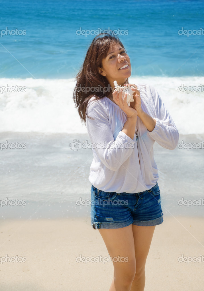 Beautiful woman with seashell on the beach