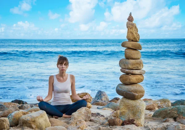 Женщина Янг практикует йогу у океана — стоковое фото
