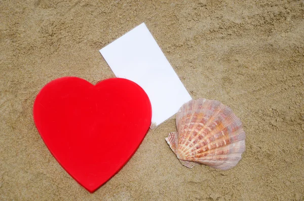 समुद्र तट पर दिल, समुद्री शैल और कागज — स्टॉक फ़ोटो, इमेज
