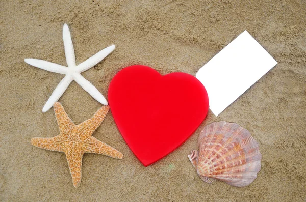 Herzform, Seesterne, Muscheln und Papier am Strand — Stockfoto