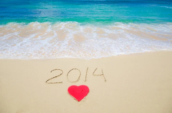 Number 2014 and heart shape on the beach — Stock Photo, Image