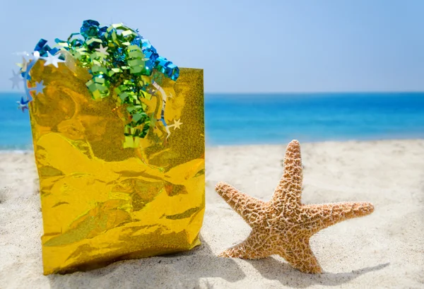 Seestern mit Geschenktüte am Strand - Urlaubskonzept — Stockfoto