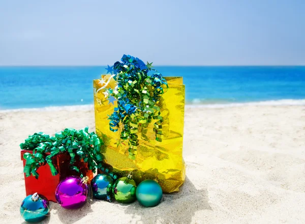 Geschenkbox und Geschenktüte am Strand - Urlaubskonzept — Stockfoto