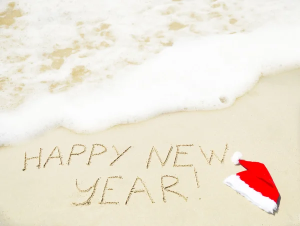 Sign "Happy new year" on the sand - holiday concept — Stock Photo, Image