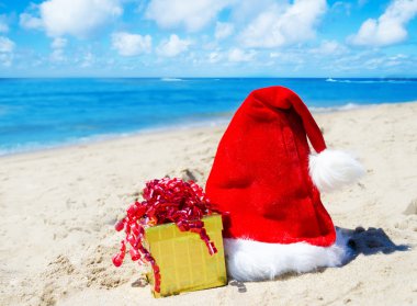 Sahilde hediye kutusu ile Noel şapka
