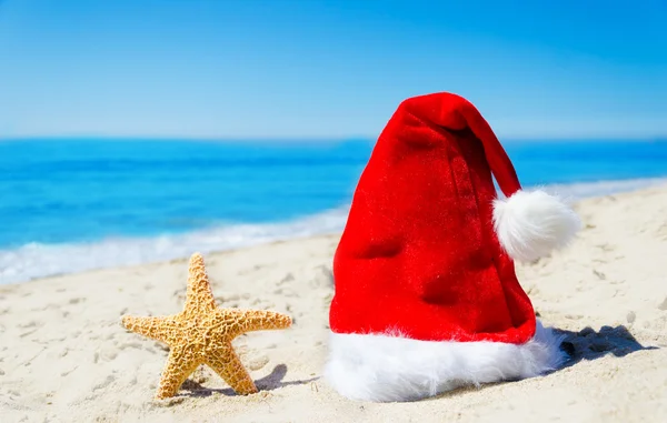 海滩上的海星的圣诞帽子 — 图库照片