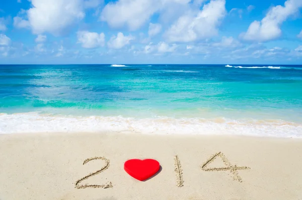 Number 2014 with heart shape on the sandy beach — Stock Photo, Image