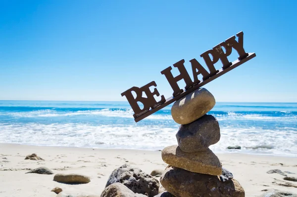 Sign "Be Happy" on balanced rocks — Stock Photo, Image