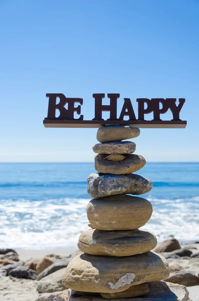 Sign "Be Happy" on balanced rocks — Stock Photo, Image