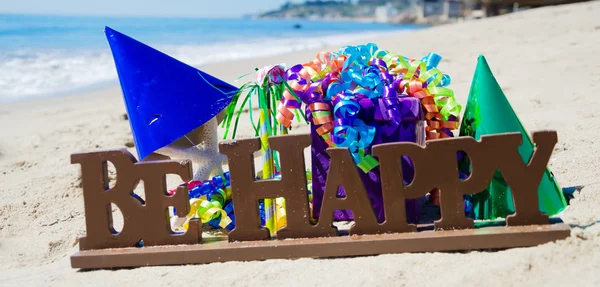 Podepište, "být šťastný" s narozeninové dekorace na pláži — Stock fotografie
