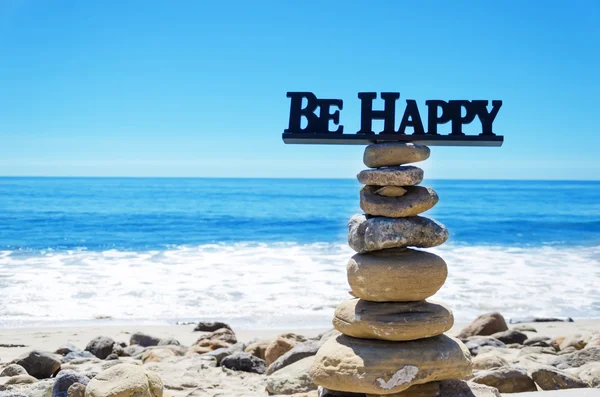 Sign "Be Happy" on balanced rocks — Stock Photo, Image