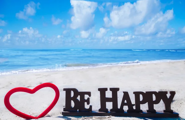 Firma "Sé feliz" con el corazón en la playa — Foto de Stock