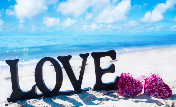 Sign "LOVE" with hearts on the beach — Stock Photo, Image