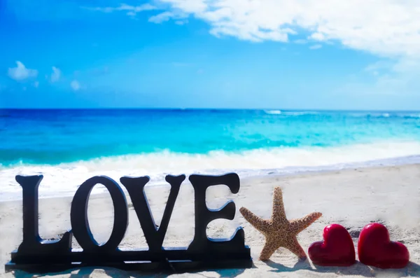 Señal "Amor" con formas de corazón y estrellas de mar —  Fotos de Stock