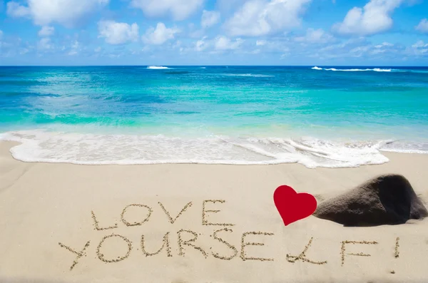 Assine "Ame-se" na praia de areia Imagem De Stock