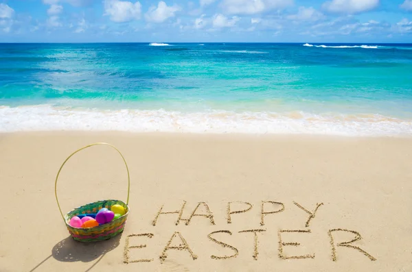Sign "Happy Easter" with basket on the beach — Stock Photo, Image