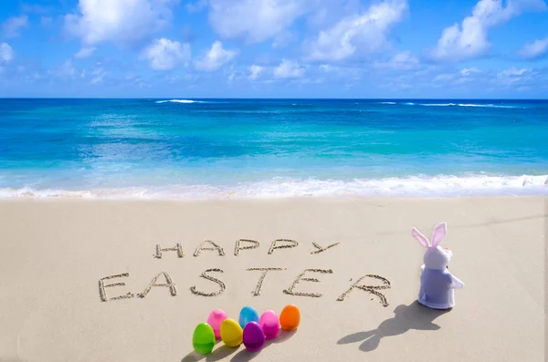 Sign "Happy Easter" with bunny on the beach — Stock Photo, Image