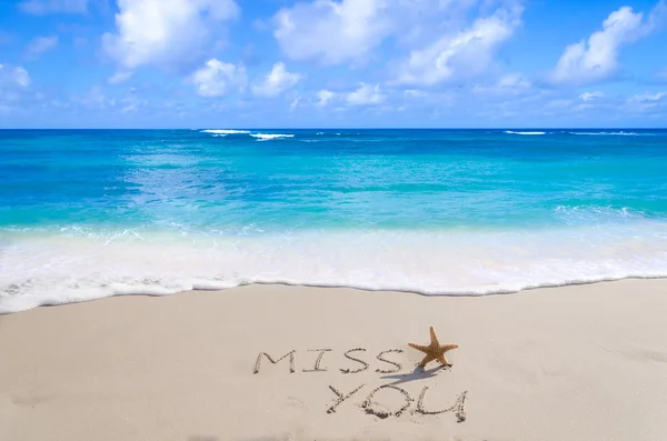 Sign "Miss you" with starfish on the beach — стоковое фото