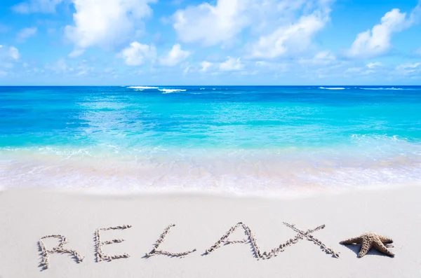 Firma "Relájate" con estrellas de mar en la playa —  Fotos de Stock