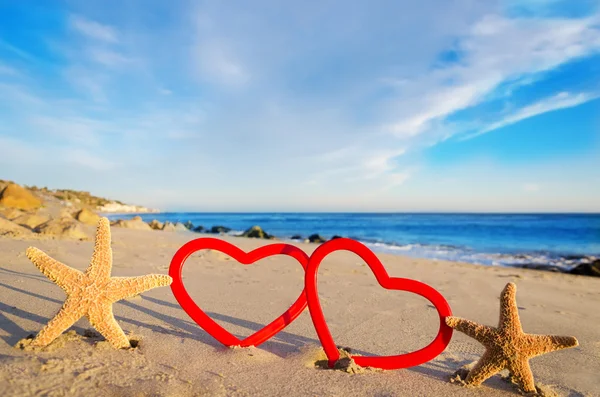Starfishes com corações na praia de areia — Fotografia de Stock