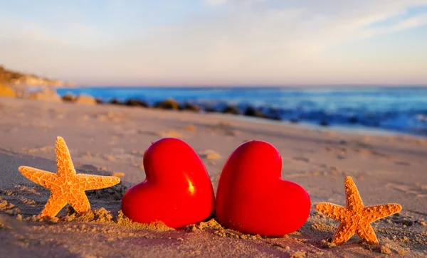 Starfishes com corações na praia de areia — Fotografia de Stock