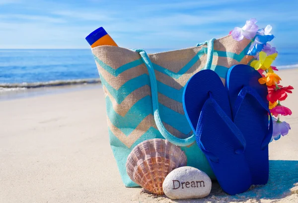 Bolsa de praia com chinelos junto ao oceano — Fotografia de Stock