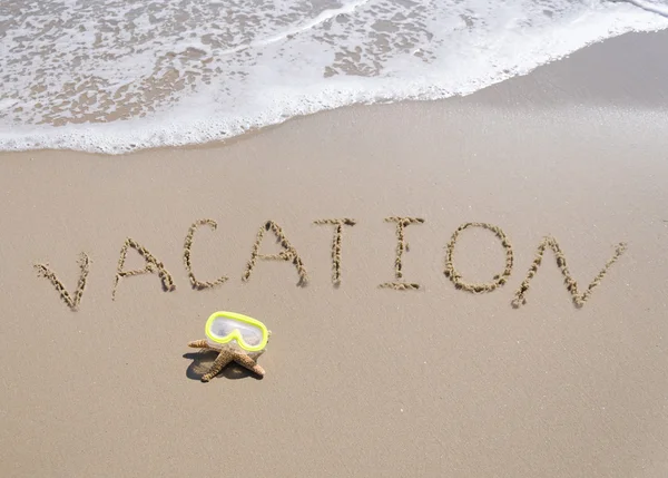 Sign "Vacation" on the sandy beach with starfish — Stock Photo, Image