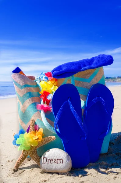 Beach bag with flip flops by the ocean — Stock Photo, Image