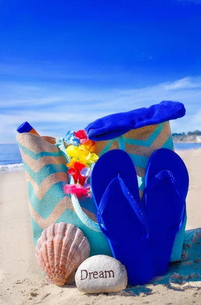 Beach bag with flip flops by the ocean — Stock Photo, Image