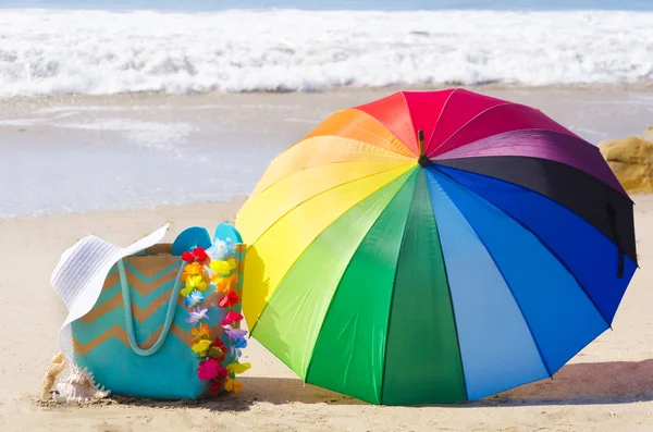 Fond d'été avec parapluie arc-en-ciel et sac de plage — Photo