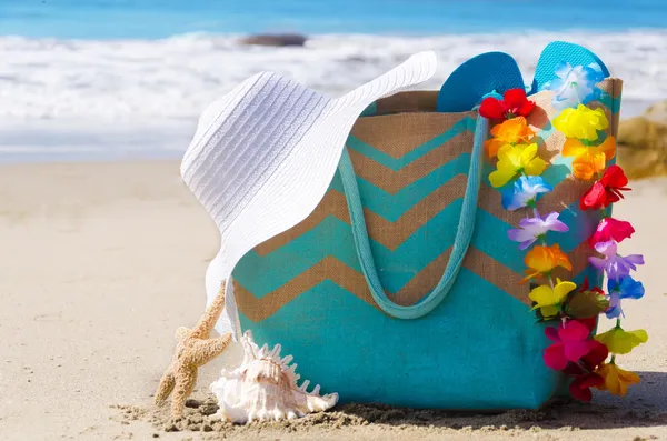 Bolsa de playa con chanclas junto al océano —  Fotos de Stock