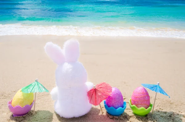 Paskalya tavşanı ve renk yumurta sahilde — Stok fotoğraf