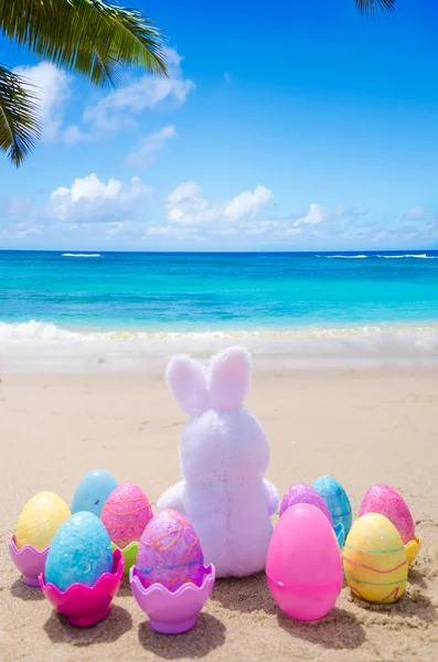Coelho da Páscoa e ovos de cor na praia — Fotografia de Stock