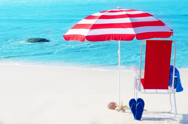 Sombrilla de playa y silla por el océano — Foto de Stock