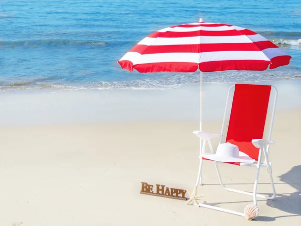 Beach umbrella and chair by the ocean — Stock Photo, Image