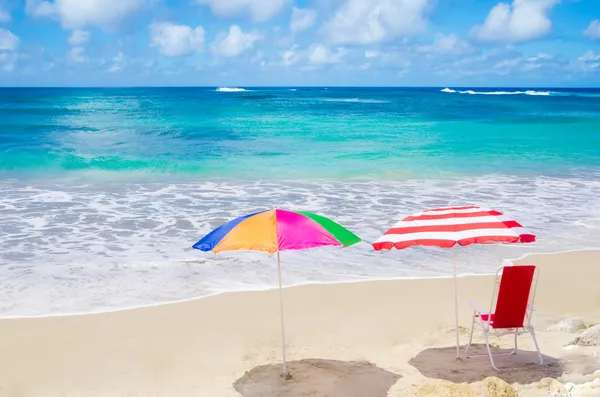 Guarda-chuvas de praia e cadeira junto ao oceano — Fotografia de Stock