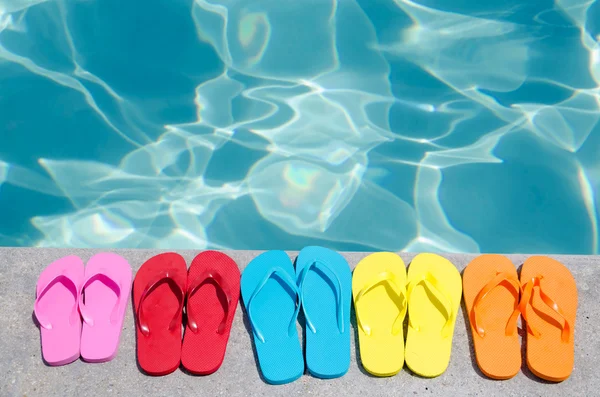 Färg flip flops vid poolen — Stockfoto