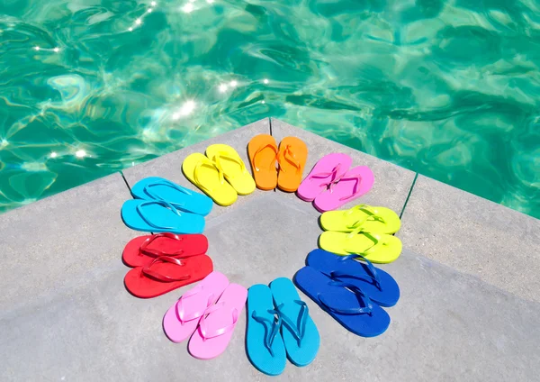 Färg flip flops vid poolen — Stockfoto