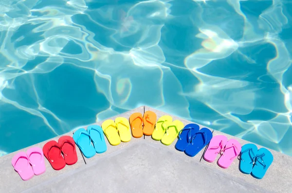 Färg flip flops vid poolen — Stockfoto