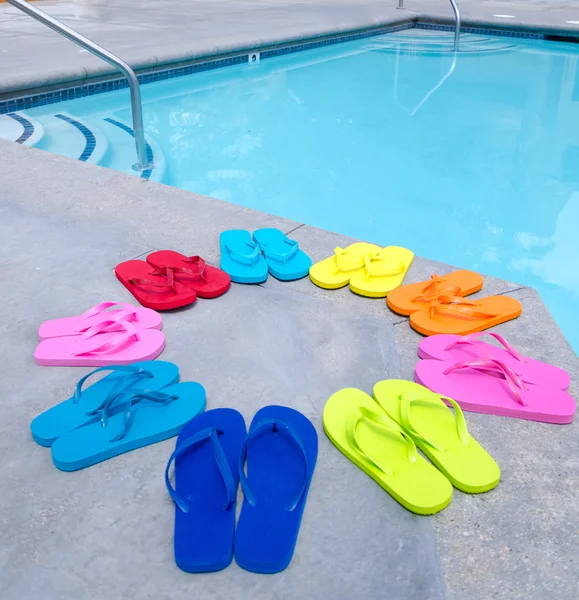 Färg flip flops vid poolen — Stockfoto