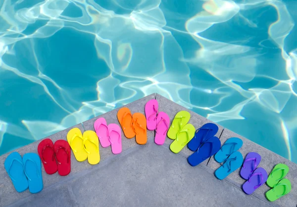 Färg flip flops vid poolen — Stockfoto
