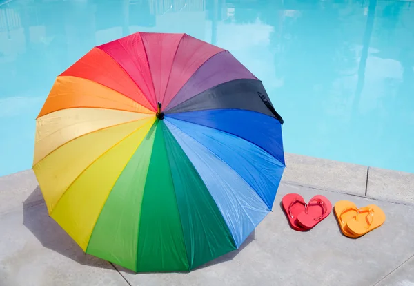 Кольорова парасолька і фліп-флоп біля басейну — стокове фото