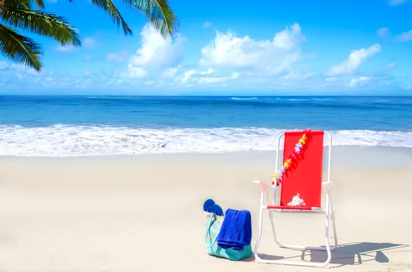 Beach chair and bag with flip flops by the ocean — Stock Photo, Image