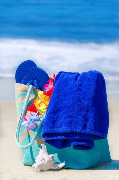 Bolsa de praia com chinelos junto ao oceano — Fotografia de Stock