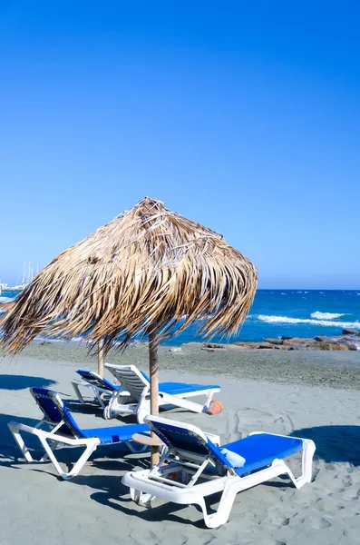 Плетеный зонтик на пляже — стоковое фото