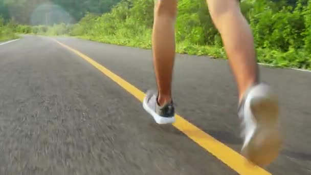 10代の男の子がマラソンとフィットネスのための朝のトレーニングで道を走っています 健康的なライフスタイルのコンセプト 屋外で運動をしている運動選手 足を閉じて — ストック動画
