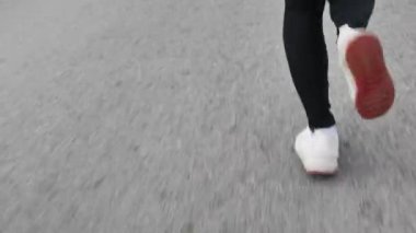 Bayan koşucular sabah maraton ve fitness antrenmanı için yolda koşuyorlar. Sağlıklı yaşam tarzı kavramı. Sporcu dışarıda egzersiz yapıyor. Bacaklarını kapat..