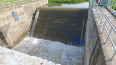 Barajdan su akması. Düşük barajdan akan su manzarası güçlü akıntıyla birlikte. Kaygan taşlar ve beyaz köpük oluşumu. Hidroelektrik santrali.