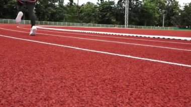 Stadyum pistinde spor kıyafetleriyle koşan atletik bir kadın. Kadın koşucu egzersiz için koşuyor. Spor Sağlıklı yaşam tarzı konsepti.